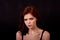 Girl in Studio on a black background. Red hair, great figure. Frowns.The state of irritation and discontent