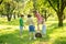 Girl on stump and friends together on lawn