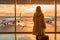 Girl with suitcase at airport window