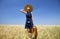 Girl with suitcase at spring wheat field.