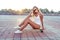 Girl in summer city, sitting longboard skateboard, long hair, sunglasses, white bodysuit swimsuit sneakers. Concept
