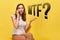 A girl in summer clothes on a yellow background sits and swears on the phone - the word WTF