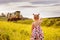 girl in summer dress and pigtails looking at the train at sunset