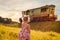 girl in summer dress and pigtails looking at the train at sunset