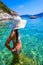 Girl with sun hat relaxing and swimming at Porto Timoni beach at Afionas is a paradise double beach with crystal clear azure water