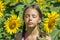 Girl sunbathes among sunflowers