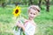 Girl with sunflower. Happy child with walks in summer park. Portrait of charming little girl with a sunflower. concept of childhoo