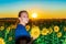 A girl among sunflowers in a field on a summer evening