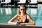 Girl in sunglasses with cocktail in swimming pool on resort