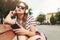 Girl with sunglasses sitting on a bench in the summer listening music over headphones