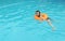 Girl in sunglasses swimming with rubber duck in swimming pool