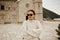 A girl in sunglasses and a white suit walks on the island. Travel, Montenegro. Boka island Church of Our Lady of the Rocks Kotor