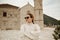A girl in sunglasses and a white suit walks on the island. Travel, Montenegro. Boka island Church of Our Lady of the Rocks Kotor
