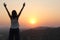 The girl at sunset. The girl stands with her back on the top of the mountain and looks at the sunset, welcomes the sun with her