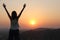 The girl at sunset. The girl stands with her back on the top of the mountain and looks at the sunset, welcomes the sun with her