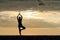 Girl at sunset practicing yoga at the seashore, silhouette