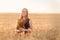 A girl at sunset in a wheat field with a bouquet. Natural farming and organic cosmetics