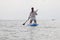 Girl on sup board. Water sport, supsurfing. Active weekend at sea, woman leisure stand