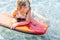 Girl surfing on tropical beach. Family summer vacation. Kid on surf body board. Travel with children. Water and beach sport. High