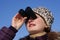 Girl with surprised looks through binoculars