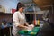 Girl sushi chef prepares food in the kitchen at restaurant