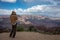 girl with sweatshirt and hoodie taking photos of the landscape of the Grand Canyon