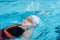 Girl swimming backstroke in pool