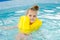 Girl swimming in the pool in the lifejacket