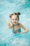 Girl in a swimming pool with a water pistol