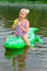 Girl swimming in the river with inflatable crocodile