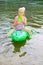 Girl swimming in the river with inflatable crocodile