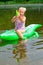 Girl swimming in the river with inflatable crocodile