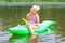 Girl swimming in the river with inflatable crocodile