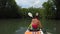 A girl is swimming in a sea kayak with oars among jungle