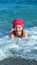 Girl swimming in the sea and playing in the coastal strip