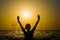 Girl swimming in the sea at sunset, splashes of transparency water, female black silhouette