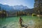 Girl in swimming suite with the back at the camera swimming in a beautiful mountain lake, in the Bavarian Alps