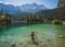 Girl in swimming suite with the back at the camera swimming in a beautiful mountain lake, in the Bavarian Alps