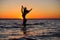 The girl swims in the sea, splashes in the water at sunset. Relaxation and happy pastime. Summer vacations. Water kick