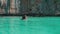 Girl swims in turquoise ocean`s water
