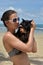 a girl in a swimsuit on the beach with a black cat