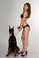 Girl in swimsuit with Doberman on white backgro