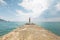 A girl in a swimsuit is standing on the pier.