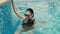 Girl in swimsuit stands on the edge of the pool in the water