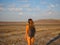 A girl in a swimsuit is walking at sunset over a dry salt lake