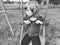 Girl on a swing. Monochrome retro photography. A child in a sports uniform is swinging. In the background is the stadium. Sadness