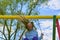 Girl swinging high. Young child on swing outdoors. Little child blond girl having fun on a swing outdoor.