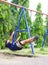 Girl swinging swing in the garden.