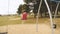 Girl swinging on a swing on the playground with her back turned