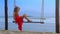 Girl Swings on Beach Rope Bench Looks at Blue Sea